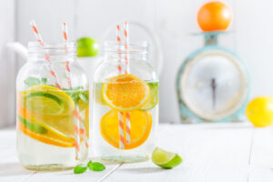 Refreshing citrus-infused water in a pitcher with lemon, lime, orange slices, and mint leaves